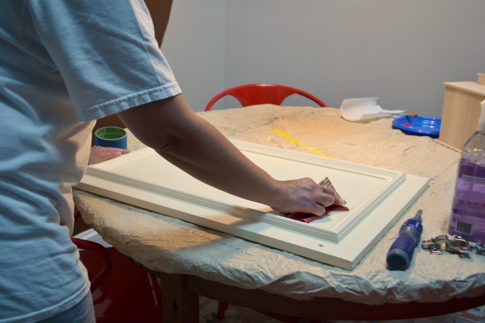 Sand the cabinet doors - How to turn a cabinet door into a memo board - thediybungalow.com