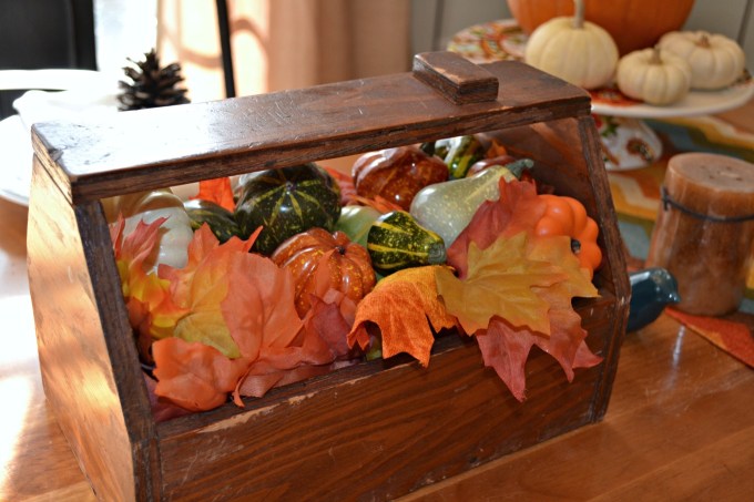 Pumpkins, gourds, and leaves in a toolbox make a centerpiece bringing natural elements to your Thanksgiving table - thediybungalow.com