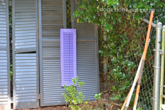 Use painted smaller shutters to cover any holes in shutters turned into a privacy screen - thediybungalow.com